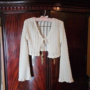 Sweater with tie front. Cropped with fun scalloped long sleeves. Cream color.